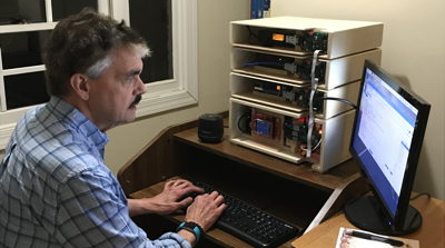Man sitting at a computer with a TARPN node box on his desk
